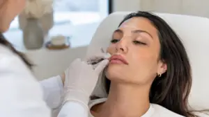 Injector performing a lip filler treatment on a client in London, Ontario